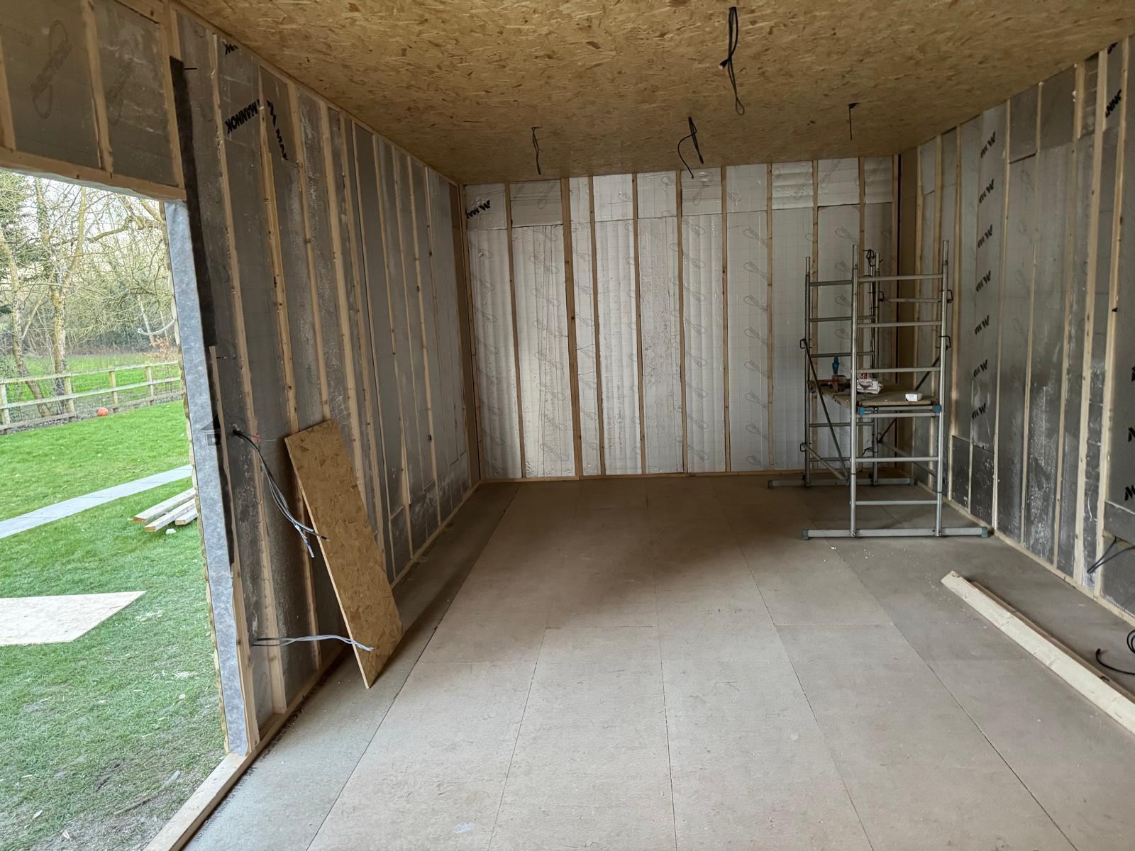 Golf simulator room insulated stud walls — Crowthorne Construction