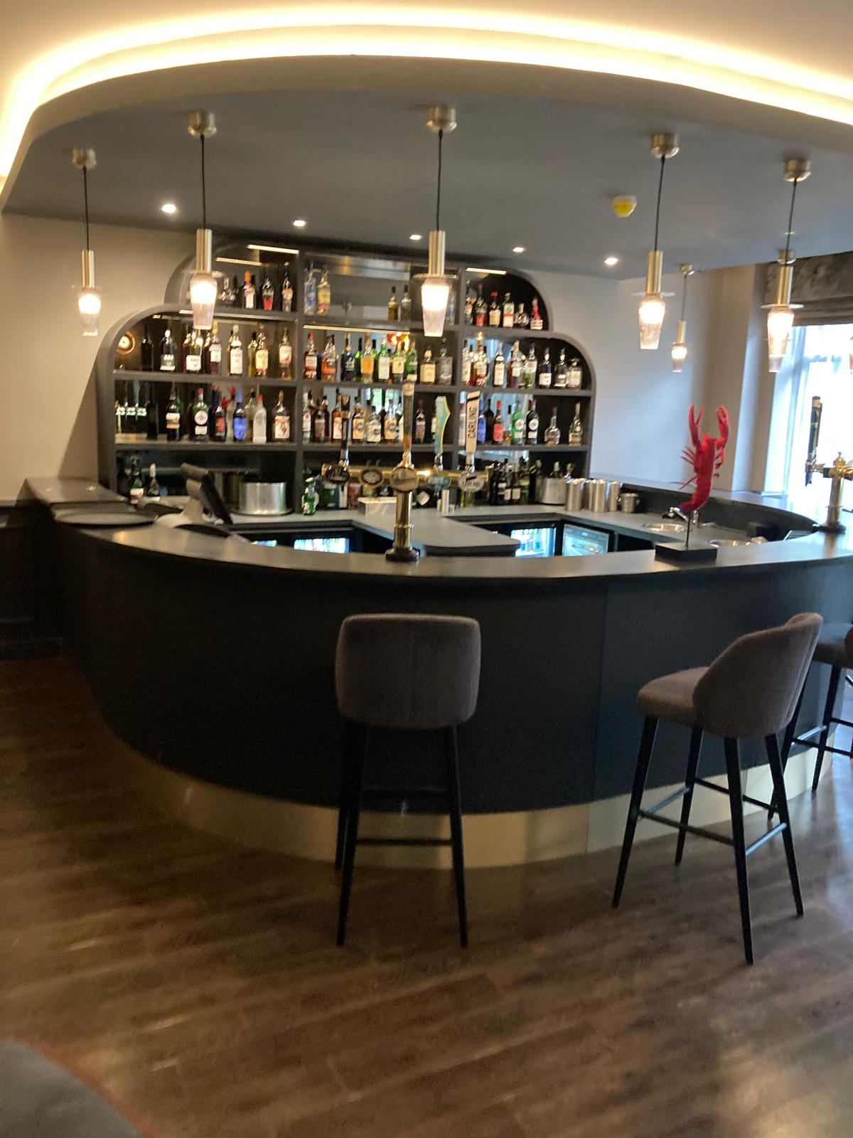 Completed hotel bar with feature lighting and full stock — Crowthorne Construction